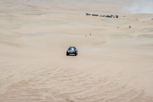 ICA, PERU - January 2013: Dakar rally, Red Bull buggy team crossing the desert with dunes.