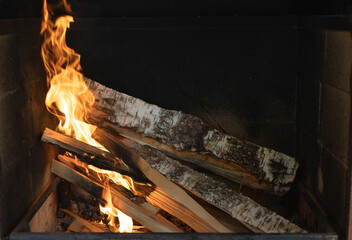 Burning fireplace. Burning birch logs in the fireplace. Warmth in cold weather