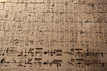 Ancient egyptian hieroglyphs carved on the walls of Ramses III temple in Luxor, Egypt 