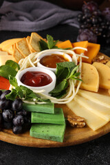 Cheese plate, wine, glasses. Cheeses, nuts, grapes, mint, sauces, honey snacks for red wine. Bar, menu, restaurant. Background image, copy space
