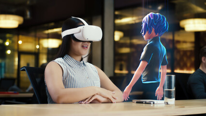 Young asian woman wearing VR headset conversing with a cartoon character avatar via an futuristic...
