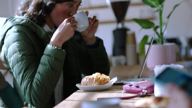 Coffee shop, morning and drinking tea of a woman in a restaurant or cafe. Person enjoying a relax, content and calm start to a day with a breakfast croissant pastry and hot drink eating and thinking