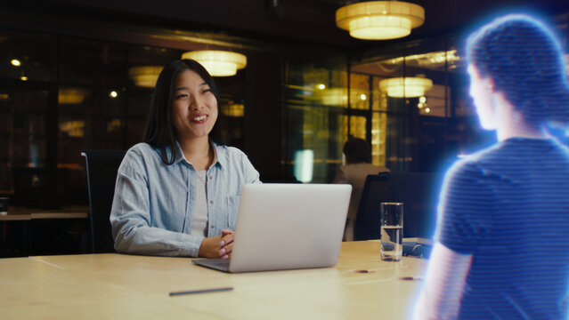 Young asian woman receives a call via an abstract futuristic screen hologram and starts talking to her friend. Futuristic communication scifi concept. 3D rendering picture. VFX.