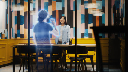 Asian woman talks on the call with her friend using augmented reality software. Hologram of her friend appears infront of her after receiving the call. VFX special effects. Virtual collaboration.