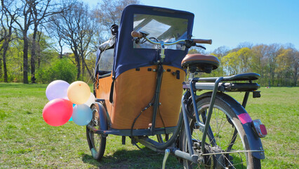 Wooden E-cargo bike with a tent with balloons parking in a forest near Berlin.