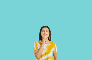 Happy smiling woman with dreamy facial expression isolated on tiffany color background. Beautiful...