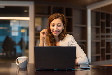 Portrait of businesswoman using laptop computer at night in office