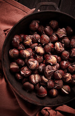 Roasted chestnuts, in an iron pan, wooden table, top view, no people, rustic style,