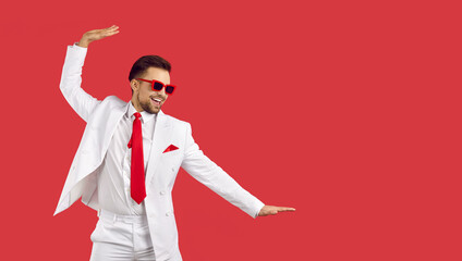 Happy funny smiling confident handsome young man wearing stylish white suit, shirt, red tie and...