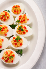 Stuffed eggs, with red caviar, micro greenery, Snack, on a white plate, top view, close-up, no people,