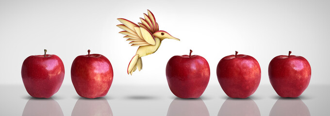 Metaphor for new idea and creative thinking as a symbol of innovation and inspiration concept as a group of red apples as one different apple transforming into a fruit sculpture of a bird in flight. 