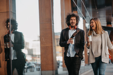 Business man and business woman talking and holding luggage traveling on a business trip, carrying fresh coffee in their hands.Business concept