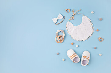 Baby shoes, bib and teethers on pastel background. Organic newborn gifts, accessories, branding,...