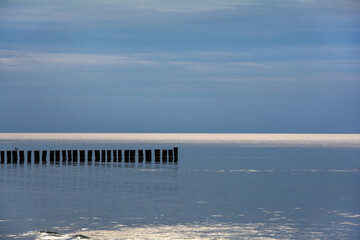 Breakwater in the calm sea with blue sky