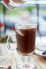 Making of sweet belgian chocolate with ice cream in glass on the terrace cafe. Delicious breakfast