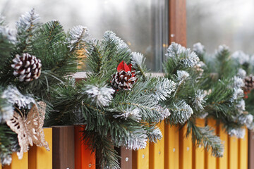 Cones hang on a snow-covered spruce garland