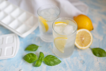 glass with refreshing ice and water alcohol cocktail and basil