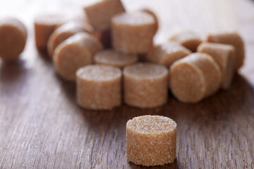 Brown round sugar forms on a old dark wooden cutting board