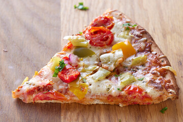 One slice of pizza  with salami, pepperoni peppers, tomatoes and onions