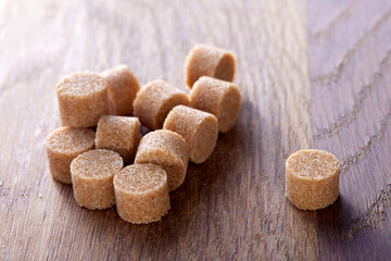 Brown round sugar forms on a old dark wooden cutting board