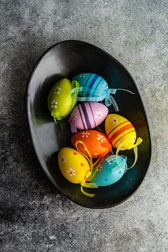 Overhead view of colourful painted easter eggs in a bowl