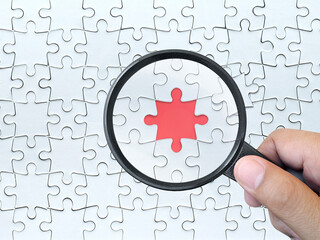 Magnifying glass searching missing puzzle peace 