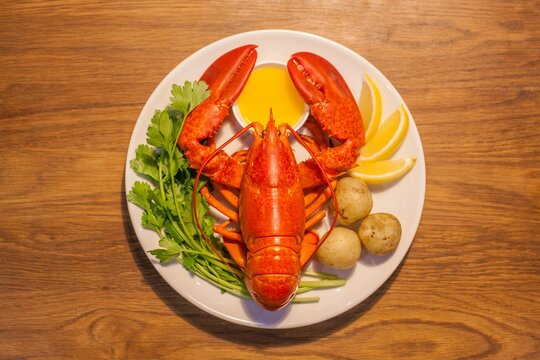 Top View Of A Plate With Lobster Crab, Lemon, Potato, Sauce And Vegetable