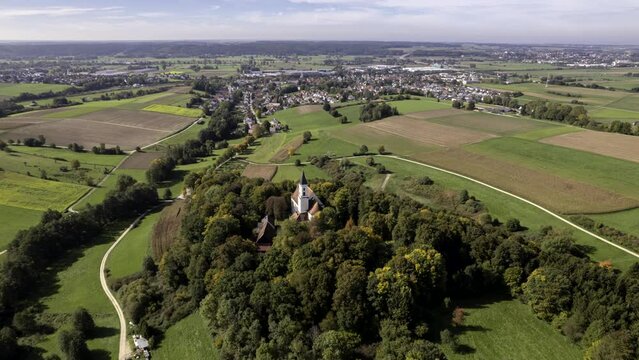 Aerial time lapse shot of the pilgrimage church Allerheiligen on a hill surrounded by a forest near Jettingen-Scheppach on a nice morning in late summer