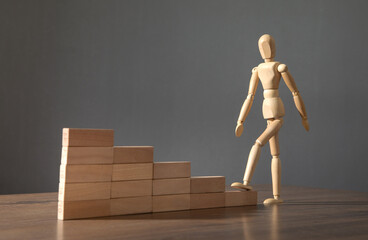 Wooden human figure climbing in stairs. Business. Career