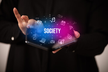 Businessman holding a foldable smartphone, social media concept
