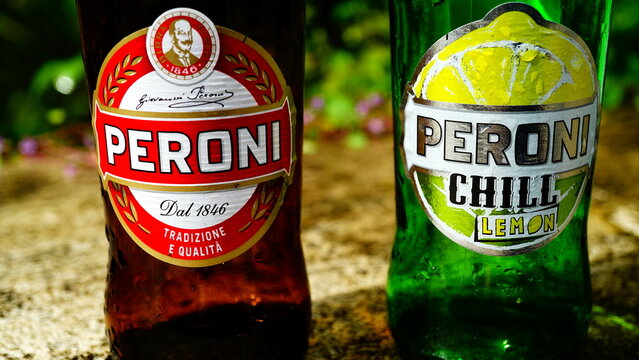 Rome, Italy - May 12, 2019: pair of empty abandoned Peroni glass bottles on a wall. classic and chill lemon added with fresh lemon juice