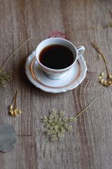 Cup of tea and pressed flowers on wooden table. Selective focus.