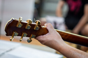 Male hands on the fret of a classical guitar
