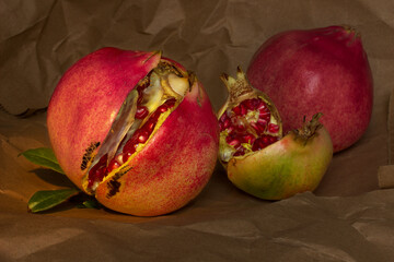 still life with three ripe pomegranates showing the grains