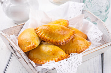 Traditional Spanish baked empanada de carne with chicken and vegetable served as close-up in a...