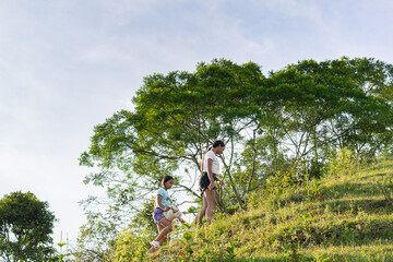 two brown-skinned Latina peasant girls, walking up a road to the top of a hill, walking home...