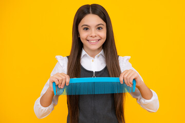 Teen girl girl with brush combing hair. Girl taking haircare and hairstyle. Hairdresser hair solon for teenager.
