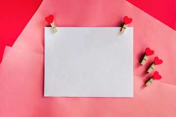 Blank greeting card with pins hearts on red and pink background. Mockup with copy space.Good for 14 february.
