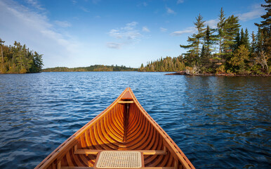 Wooden canoe on a blue Boundary Waters lake with islands on an autumn morning