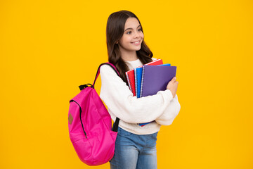 School girl hold copybook and book on yellow isolated studio background. School and education concept. Teenager girl in school uniform. Happy face, positive and smiling emotions of teenager girl.
