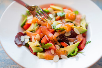 vegetable salad with hand salmon and avocado in a restaurant