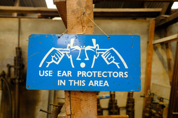 Metal sign warning to user ear protectors due to loud noises