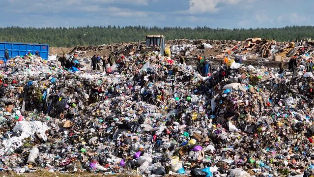 Dozer on landfill. Garbage dump with waste plastic, rubbish and polyethylene. Solid waste disposal and landfill. Landfill with solid household garbage. Environmental pollution. Waste toxic mountain. 