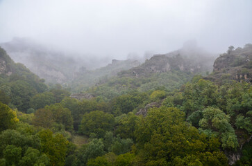 Fog view on abandoned cave city Khndzoresk in the deep gorge. Syunik region, Armenia