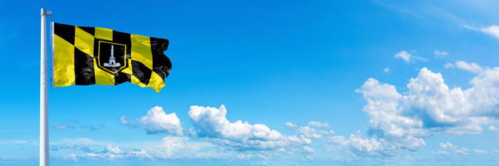 Baltimore - USA, flag waving on a blue sky in beautiful clouds - Horizontal banner