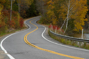Fototapeta premium Travelling on a curved road in the mountains during fall season