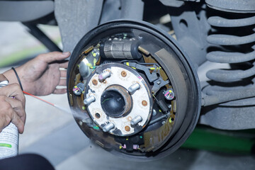 Mechanic repairing brake drums, replace new brake pads, hand brakes and cylindrical brake drums...