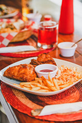 Restaurant fast food. Fried chicken with salad and French fries with dressing.