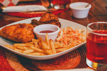 Restaurant fast food. Fried chicken with salad and French fries with dressing.