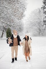 Fototapeta na wymiar Romantic couple walking in forest at winter day